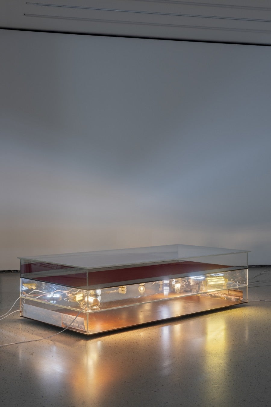 Hélène Yamba-Guimbi, Cecil Hotel (consumo), 2025. Plaques acryliques, câbles éléctriques, fixations, colle, dissipateurs thermiques, ampoules, panneau mirroir, photographies, ampoules R7S, velours rouge, gaine thermique, pads thermique, bornes Wago, bois, 150 × 68 × 38 cm. Courtesy de l’artiste. Photo : Nicolas Brasseur.