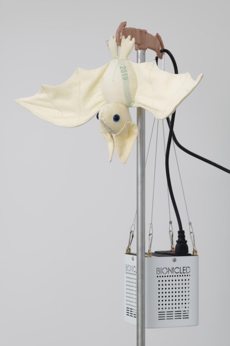 Benoît Piéron, <i>Monstera</i>, 2022. Porte serum, sparadrap, seau, goudron végétal, Monstera, lampe horticole, peluche psychopompe en patchwork de draps réformés des hôpitaux. Photo : Aurélien Mole. Courtesy de l'artiste et de la Galerie Sultana.